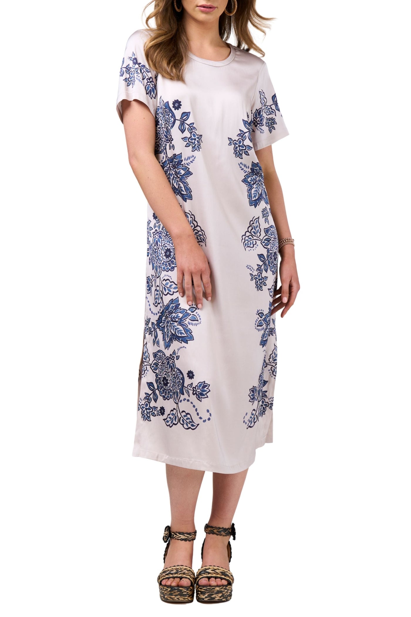 Woman wearing a white dress with blue floral patterns on a white background
