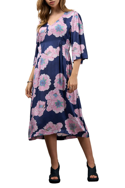Woman wearing a navy blue dress with pink floral pattern on a white background