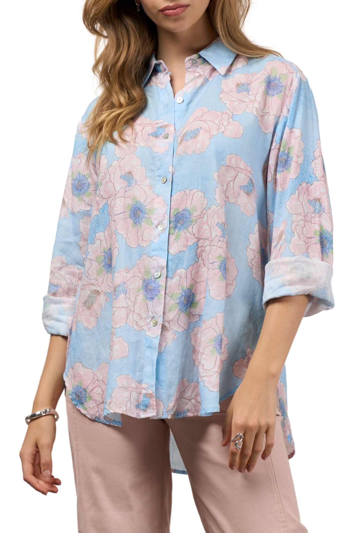 Woman wearing a floral patterned shirt with a plain background