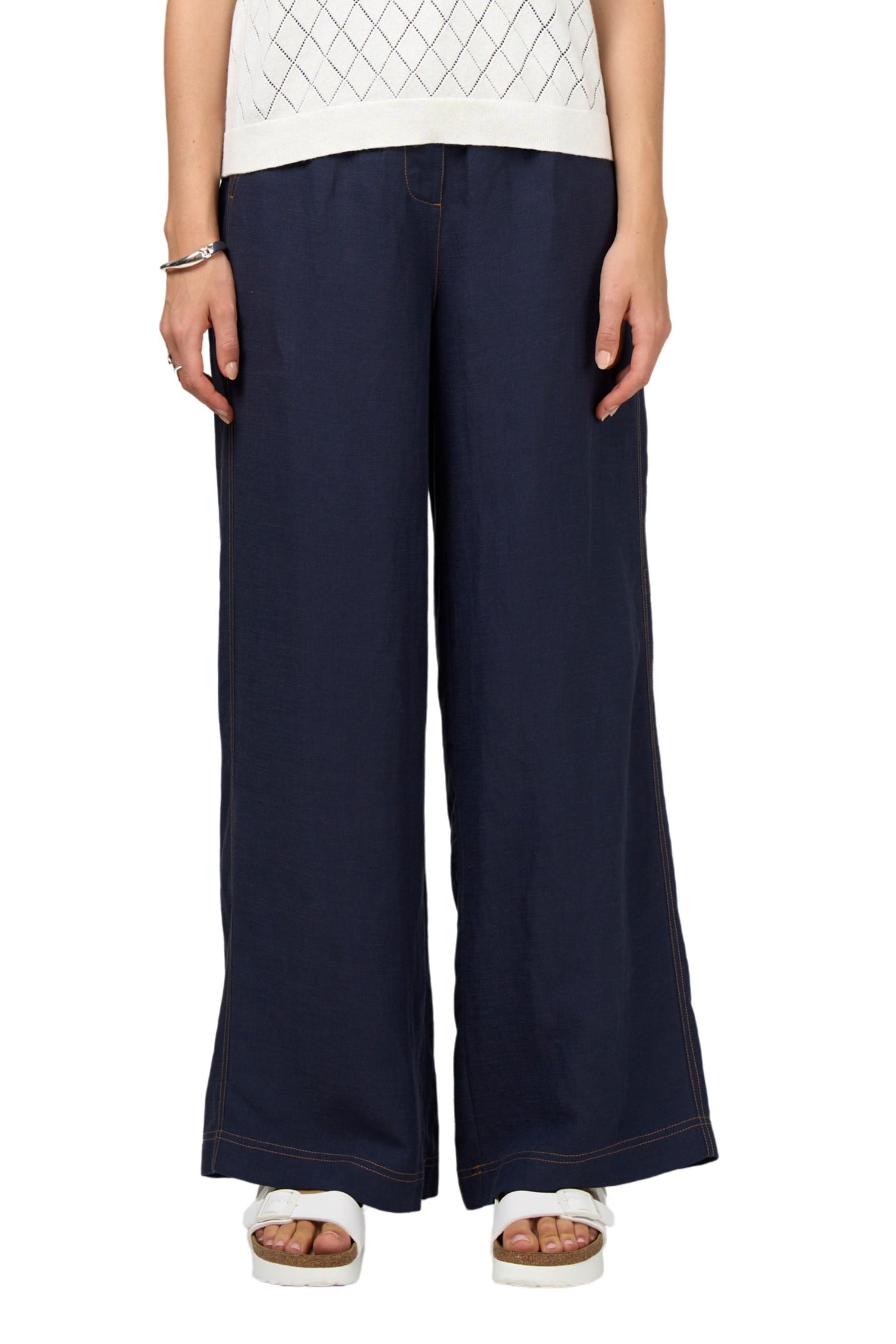 Person wearing navy wide-leg pants on a white background