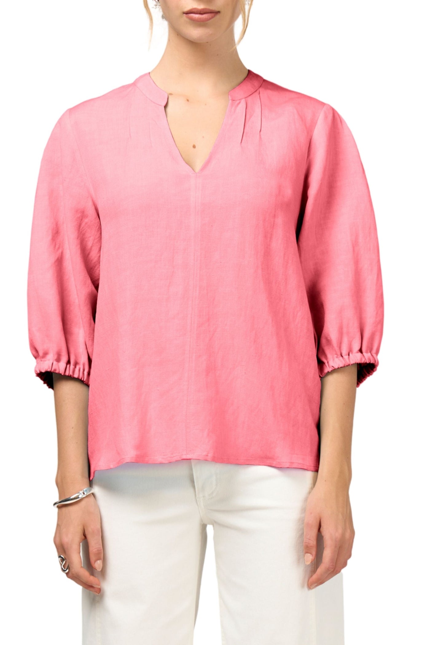 Person wearing a pink blouse with white pants on a white background