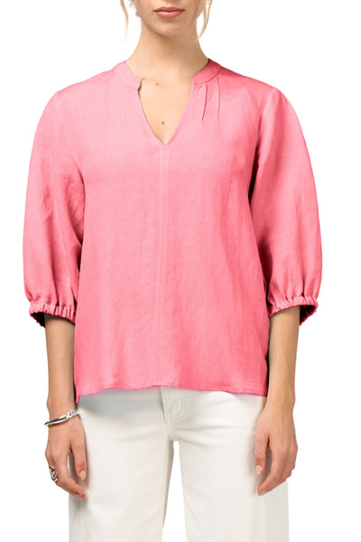 Person wearing a pink blouse with white pants on a white background
