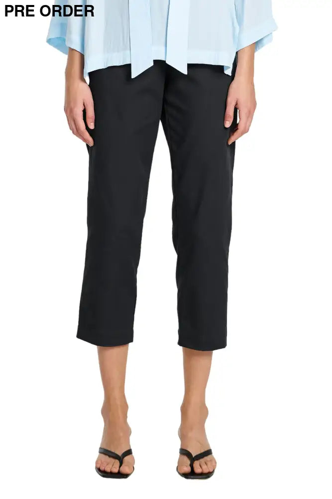 Person wearing black pants and a light blue top on a white background